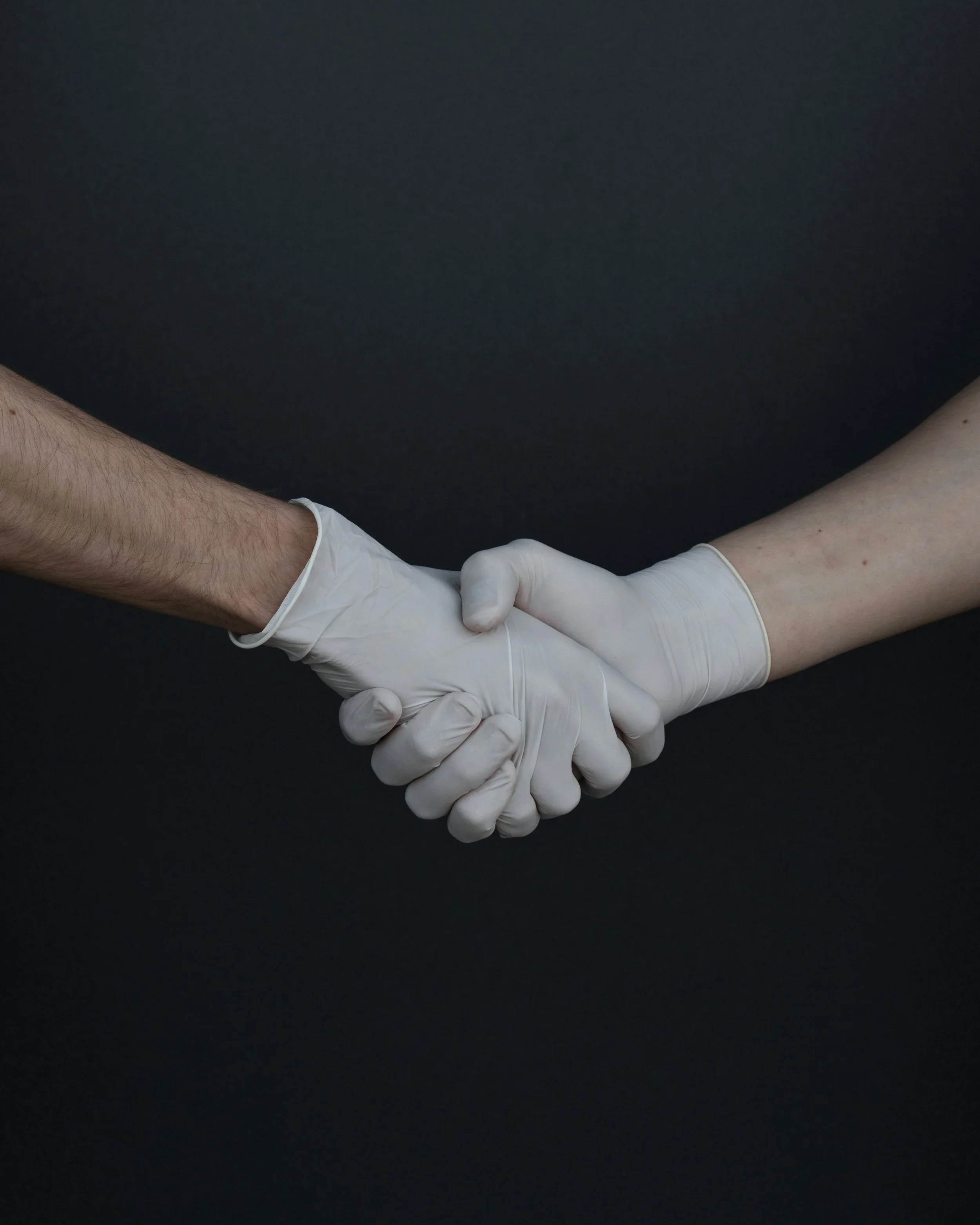 Two people shaking hands, symbolizing community partnership
