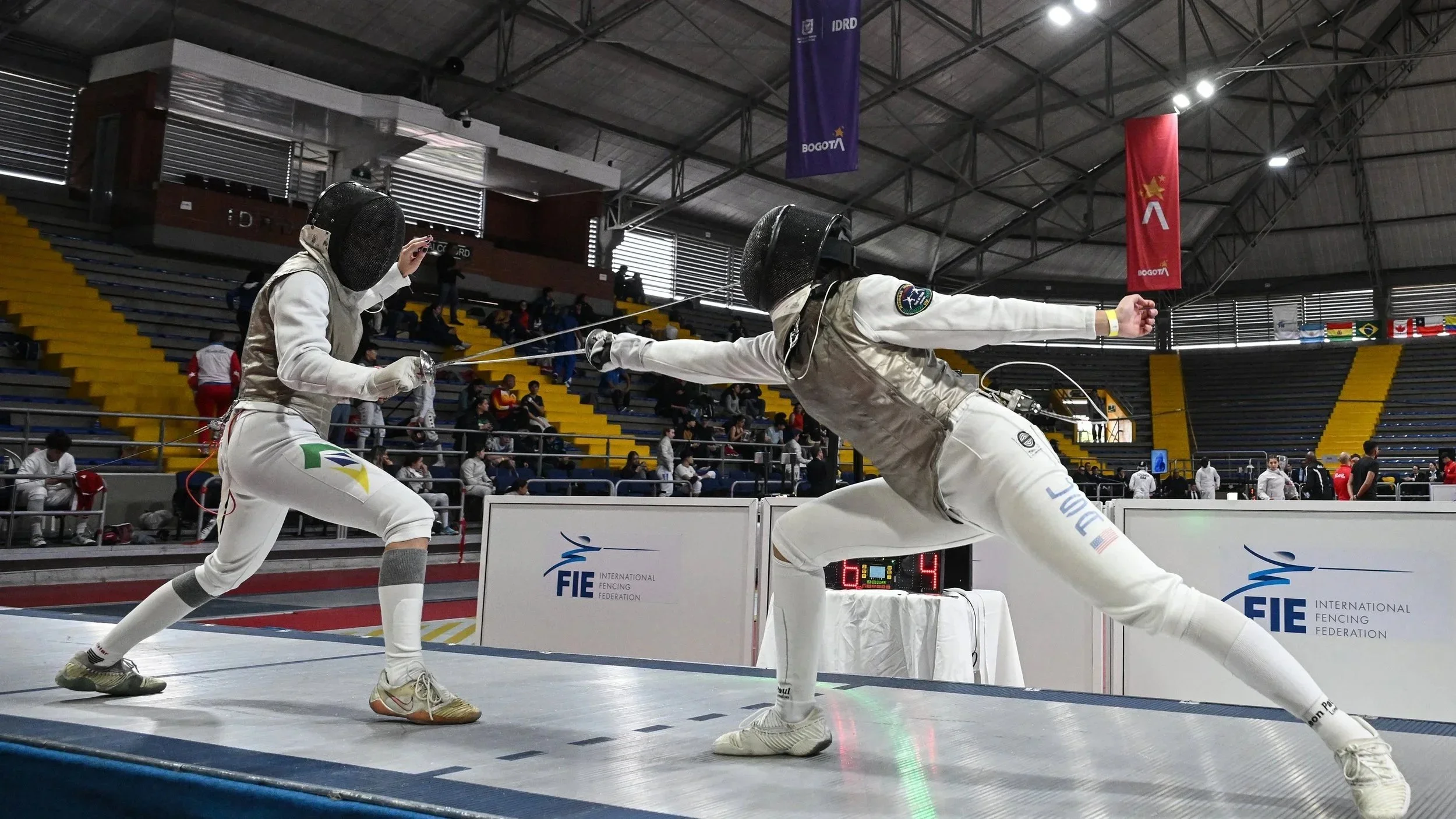 Two fencers competing in a bout at an international fencing tournament